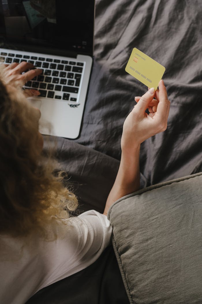 Close-up view of a person making an online purchase using a laptop and credit card.